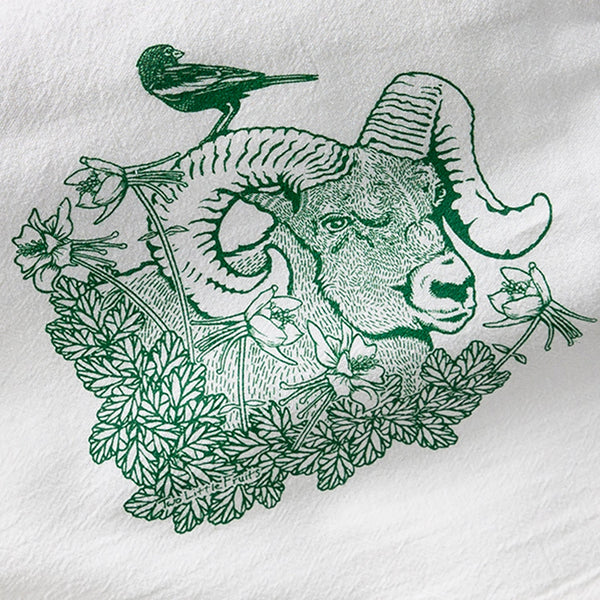 Bighorn Ram Tea Towel featuring a detailed illustration of a bighorn ram with a bird and flowers, perfect for adding charm to your kitchen.