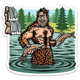 Sasquatch Sticker design depicting a cheerful Sasquatch holding fish in a river, with a lush forest in the background, created by Two Little Fruits.
