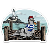 Vibrant Sea Lion Sticker with a playful sailor sea lion in a red beanie and blue stripes, set against a scenic backdrop of a lighthouse and ocean. Ideal for showcasing your style!