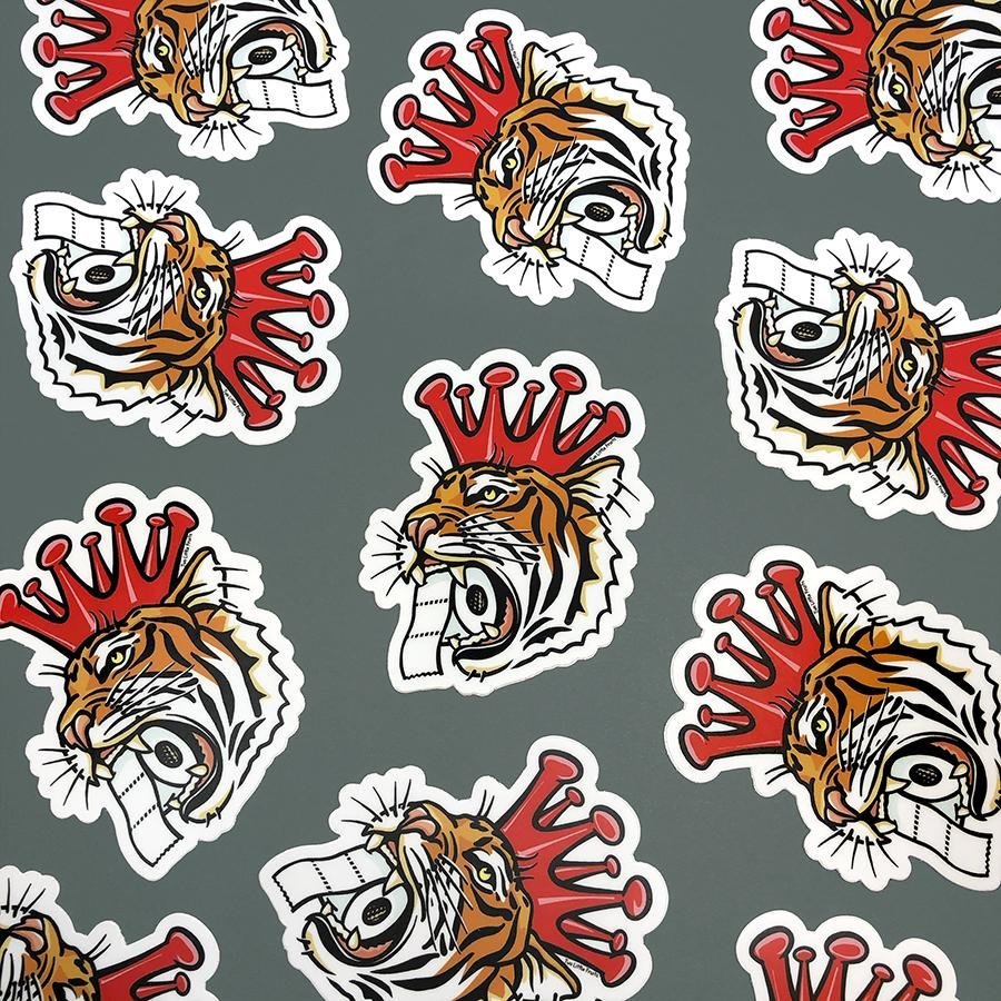 Cheerful Tiger Sticker design featuring a tiger with a toilet paper roll and a crown, perfect for adding a fun touch to any surface.