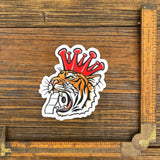 Unique Tiger Sticker design showcasing a tiger wearing a crown, holding toilet paper, ideal for adding flair to your belongings.