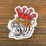 Cheerful Tiger Sticker featuring a tiger with a coronavirus crown and toilet paper in its mouth, perfect for personalizing any item.