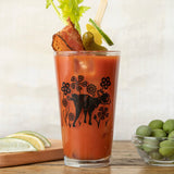 Unique Beer Glass Set depicting a playful pig amidst floral designs, perfect for craft beer lovers enjoying spicy cocktails.